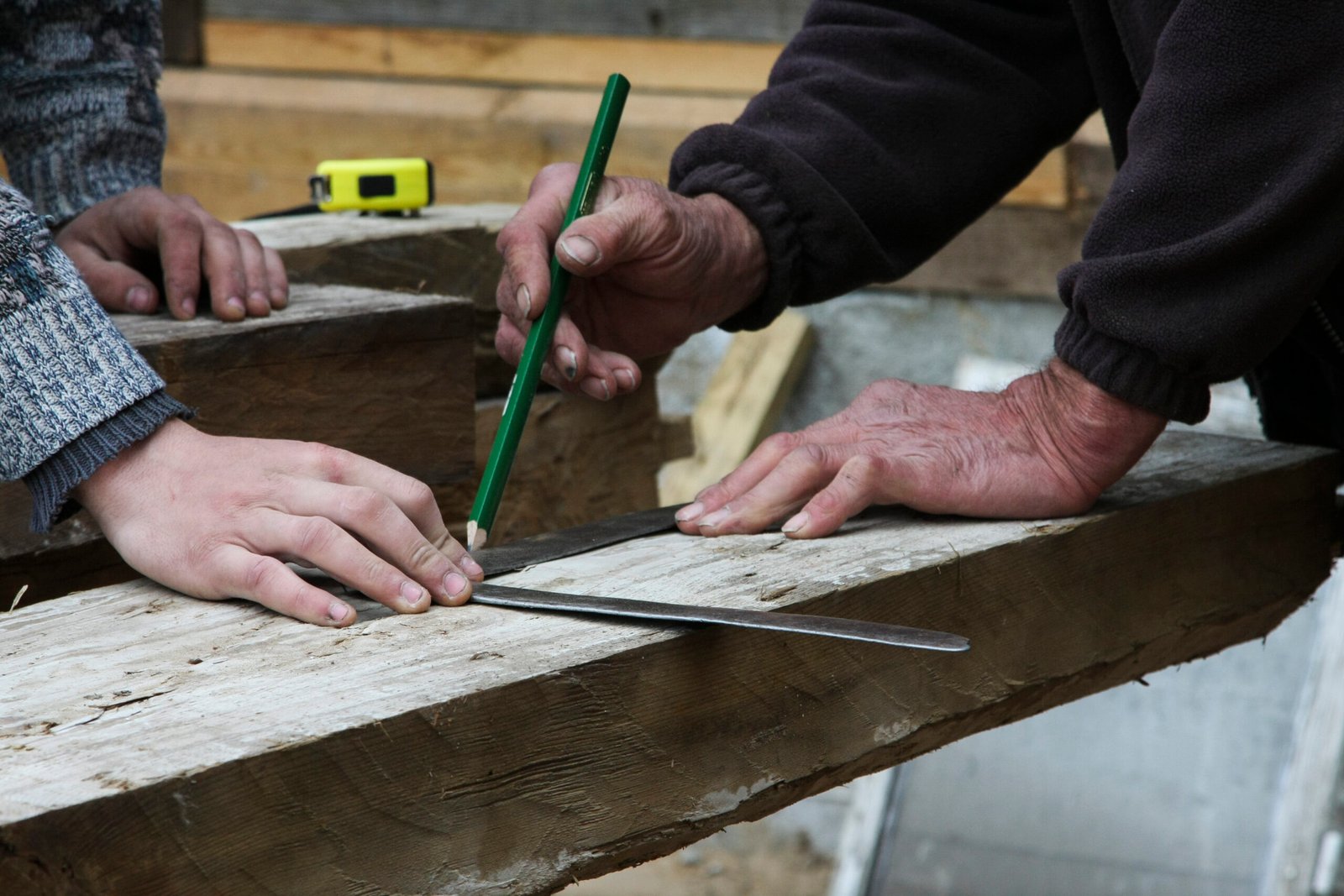 midsection carpenters measuring wood while working carpentry workshop scaled